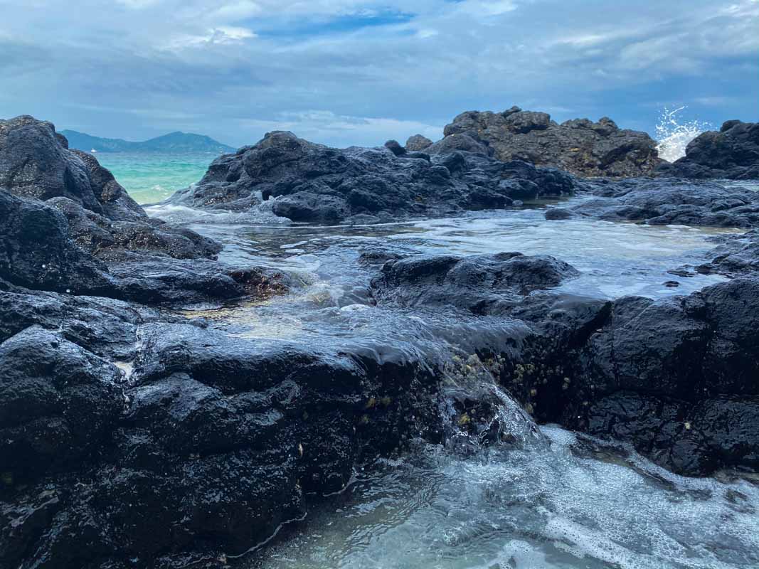 Atraksi waterblow yang indah di karang pantai